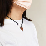 フゴッペ洞窟の人型デザインが刻印された陶製ペンダント 紐を短くした着用イメージの写真