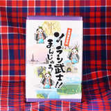 ソーラン武士！！まんじゅう。余市町のマスコットキャラクターと余市の名所風景、フゴッペ洞窟、ローソク岩、ニッカウイスキー、余市川の桜並木、ワイナリーの風景がイラストで描かれています。