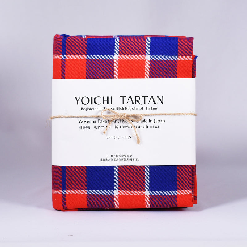 YOICHI  Tartan  余市タータン 　播州織タータン生地　ラージチェック　1mの写真。赤、青、白のタータンチェックの生地が白い包装紙に包まれている。