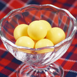 つぶらな林檎の盛り付け写真。黄色いチョコレートボールをガラスの器に盛り付けています。